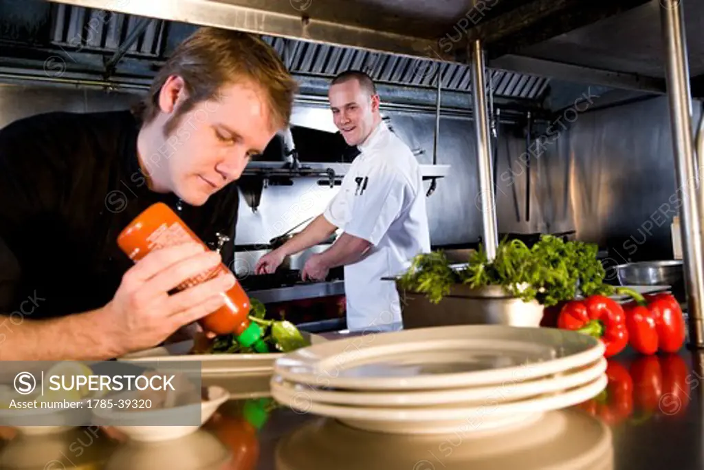 Sous chef in commercial kitchen preparing dishes