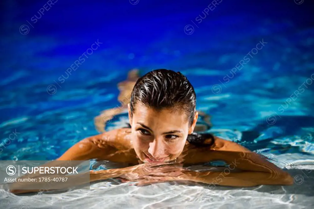 Portrait of mid-adult woman relaxing in swimming pool
