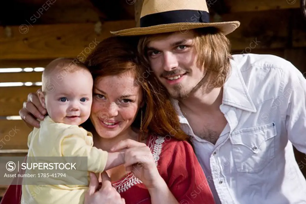 Young family with baby inside barn