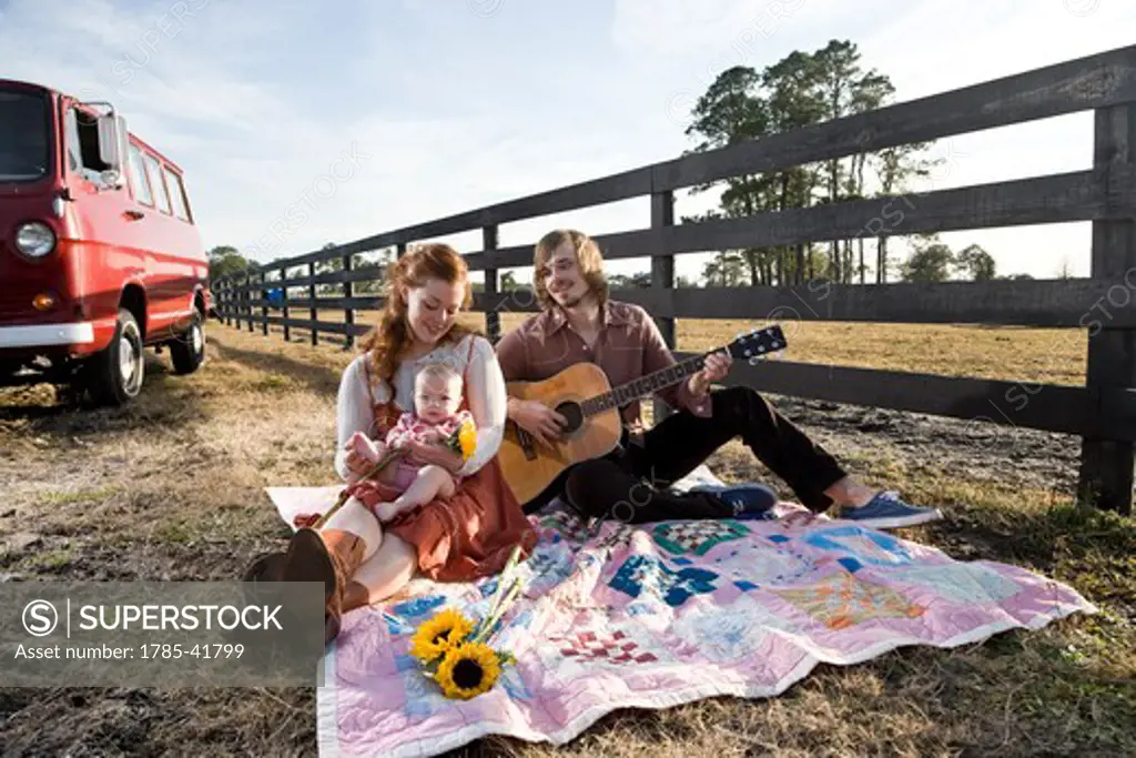 Young rural family relaxing on farm