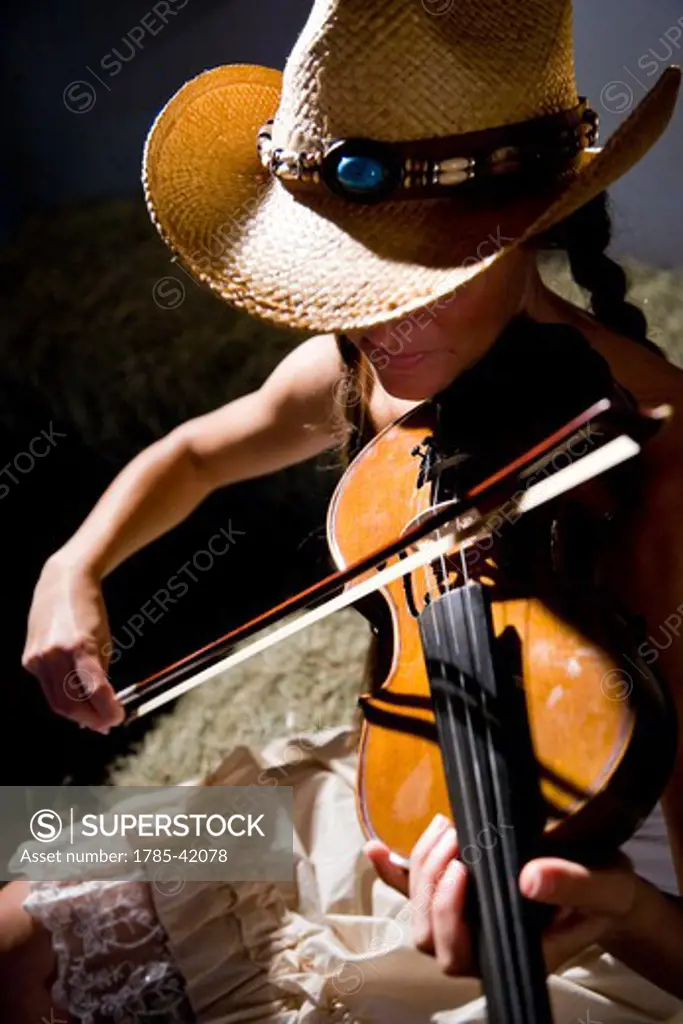 Moody cowgirl playing fiddle