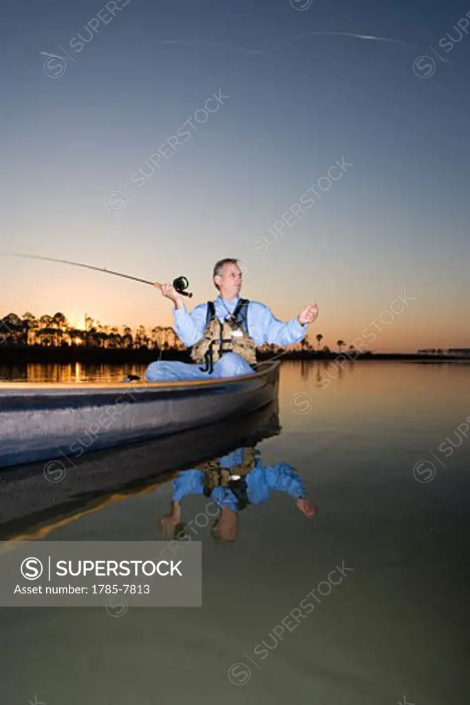 Middle-aged man fishing in canoe on Florida Intracoastal Waterway
