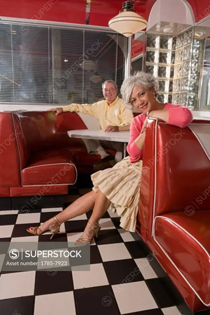 Senior couple sitting in booth of old-fashioned diner