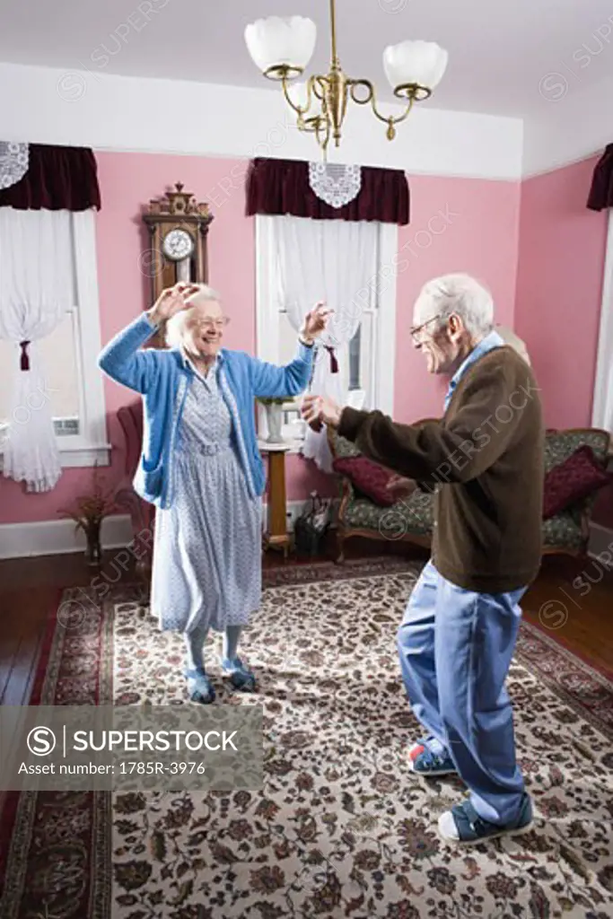 Senior couple dancing in living room
