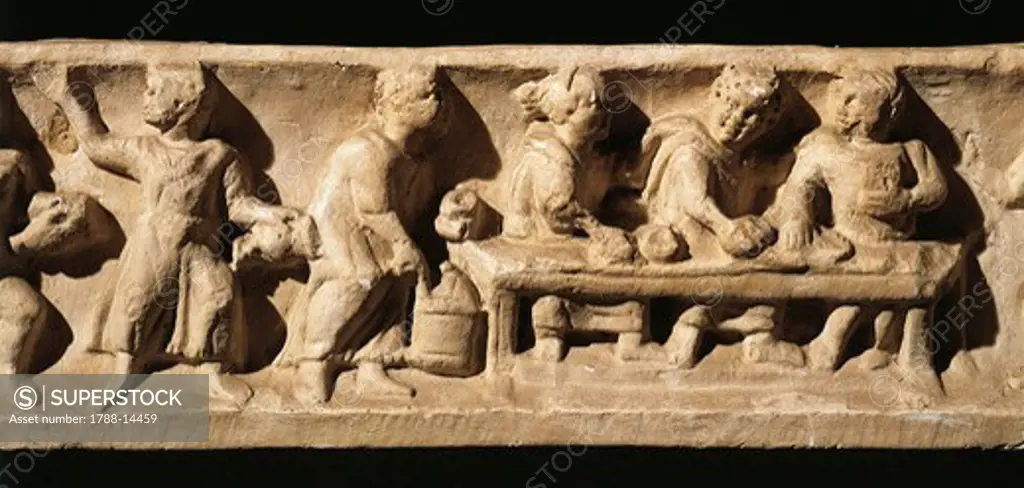 Relief portraying banquet with servants, woman, two men and sumptuously laid table