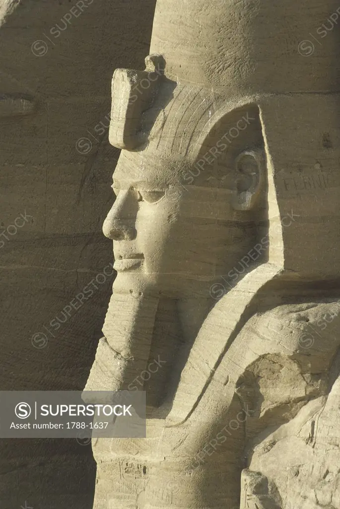 Egypt. Nubian monuments at Abu Simbel (UNESCO World Heritage List, 1979). Great Temple. Colossal seated sandstone figure of Ramses II, detail