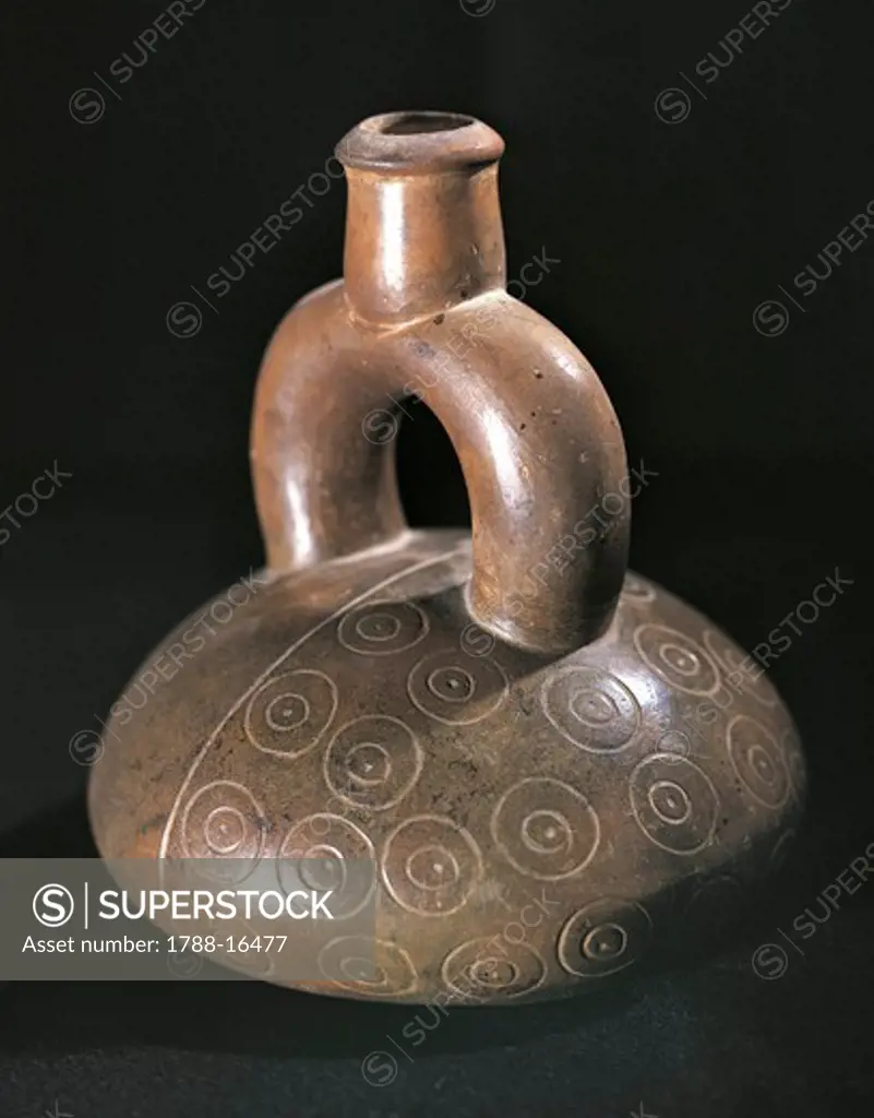 Dark ceramic stirrup spout vessel engraved with geometric patterns, Peru, Chavin culture