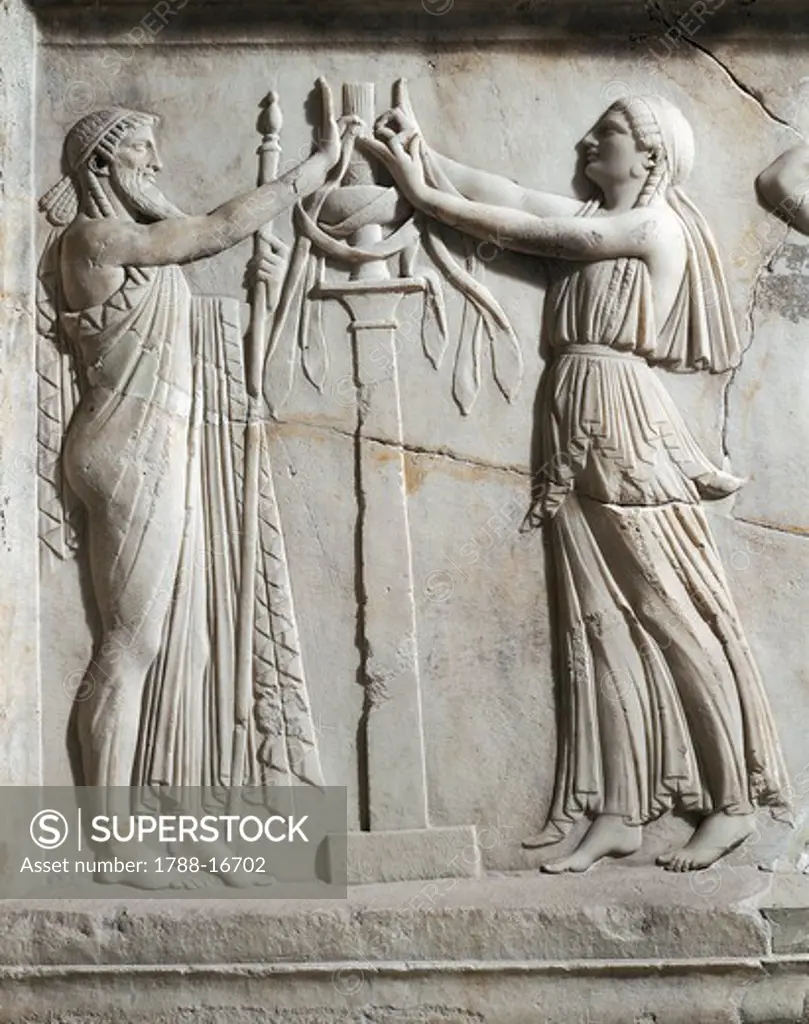 Marble slab depicting priest and priestess in ritual attitude