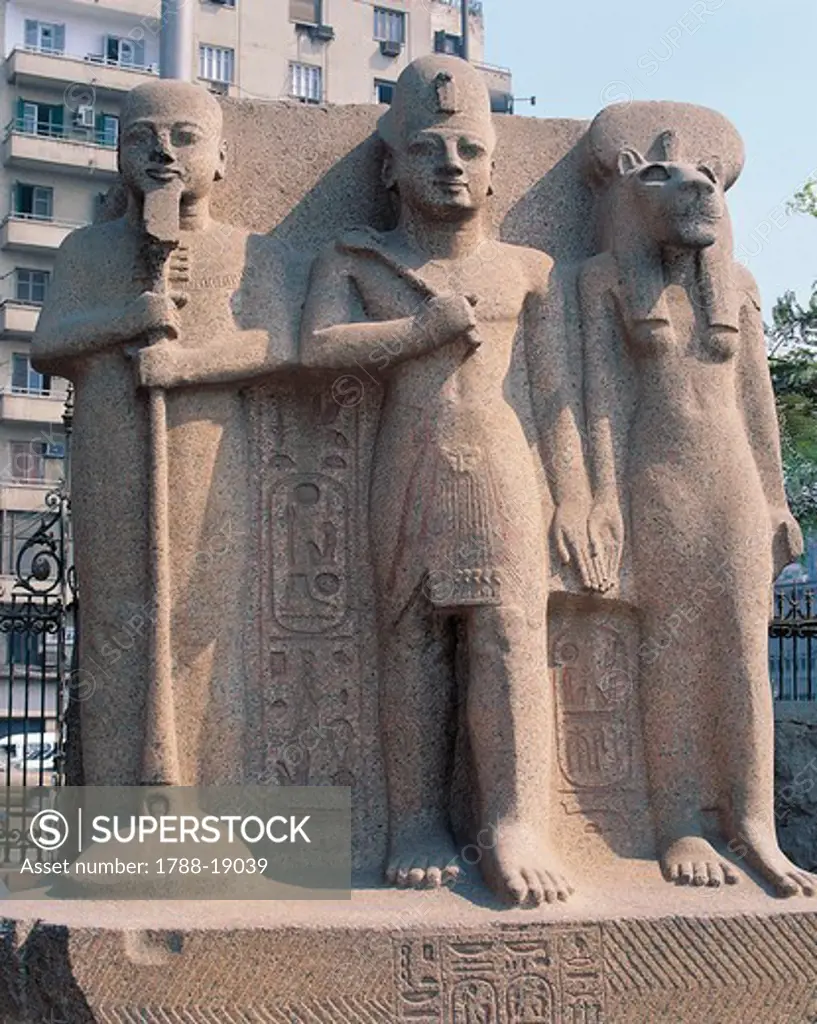 Pink granite sculptural group of the triad of Ramses II between Ptah and Sekhmet