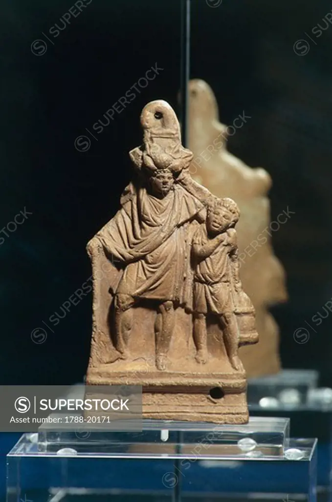 Terracotta oil lamp with figure of drunk man held up by slave