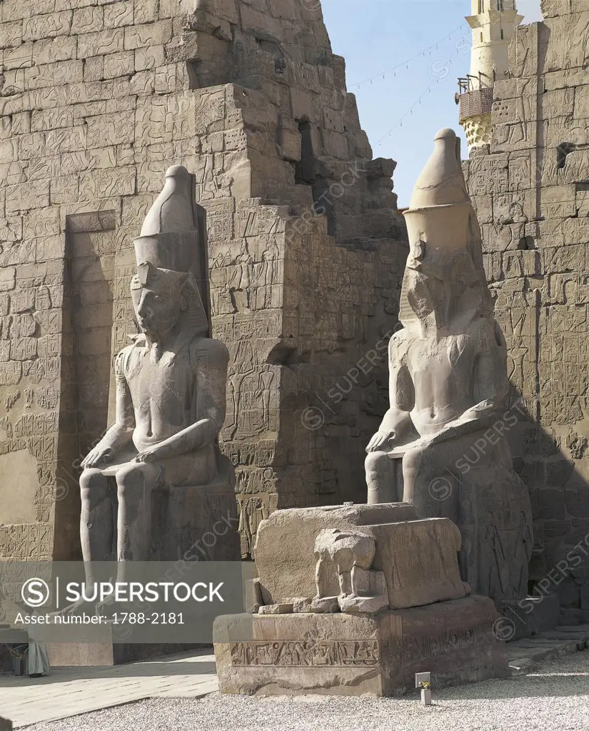 Egypt - Ancient Thebes (UNESCO World Heritage List, 1979). Luxor. Temple of Amon. Pylon of Ramses II, 1290-1224 BC. Colossal statues of pharaoh