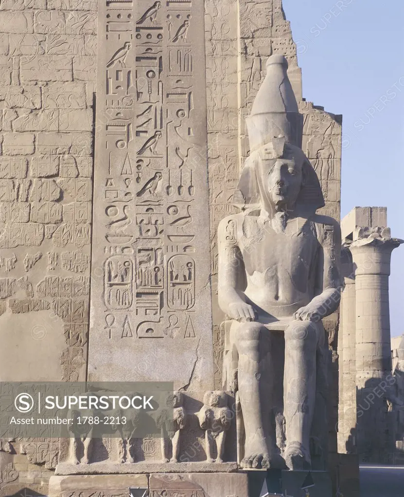 Egypt - Ancient Thebes (UNESCO World Heritage List, 1979). Luxor. Temple of Amon. Pylon of Ramses II, 1290-1224 BC. Colossal statue of Ramses II, 1290-1224 BC