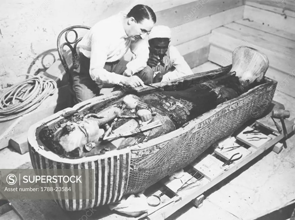 Egypt, Valley of the Kings, The discovery of the tomb of Pharaoh Tutankhamun (or Tutankhamen, circa 1340-1323 B.C., archaeologist Howard Carter (1874-1939) examining the third mummy-shaped sarcophagus, 1922, vintage photograph