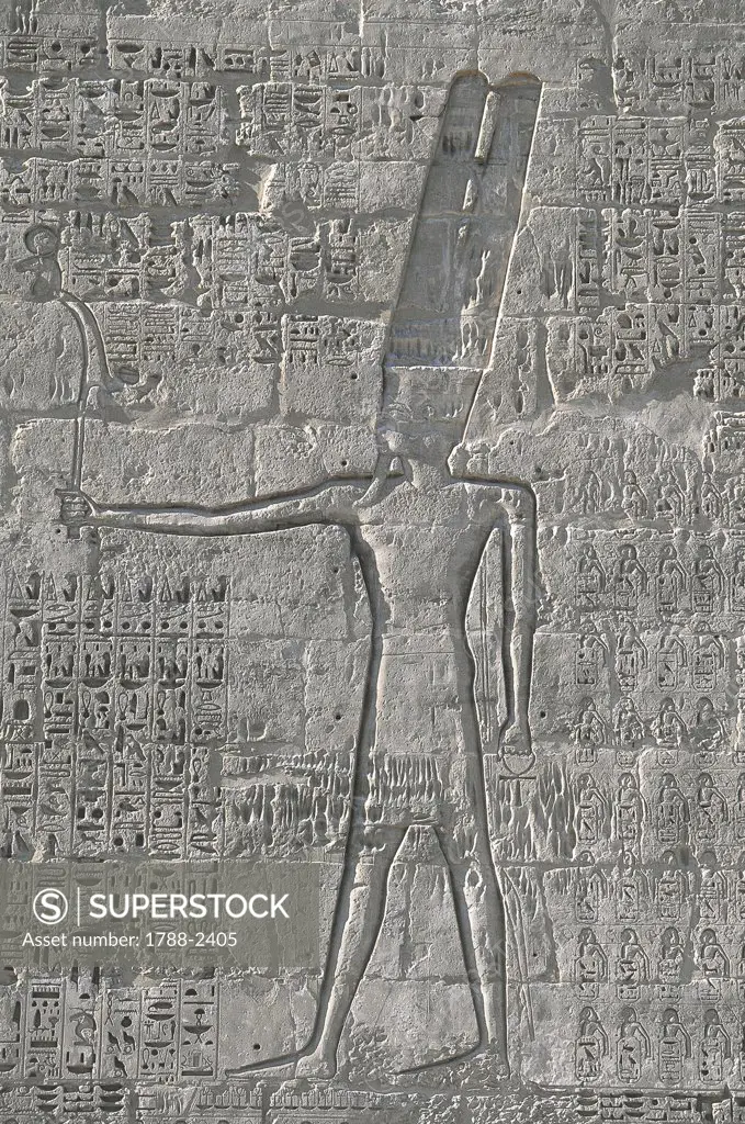Egypt - Ancient Thebes (UNESCO World Heritage List, 1979). Luxor. Fortified temple of Ramses III at Medinet Habu. Relief of god Amon-Ra-Harakhty, 19th Dynasty