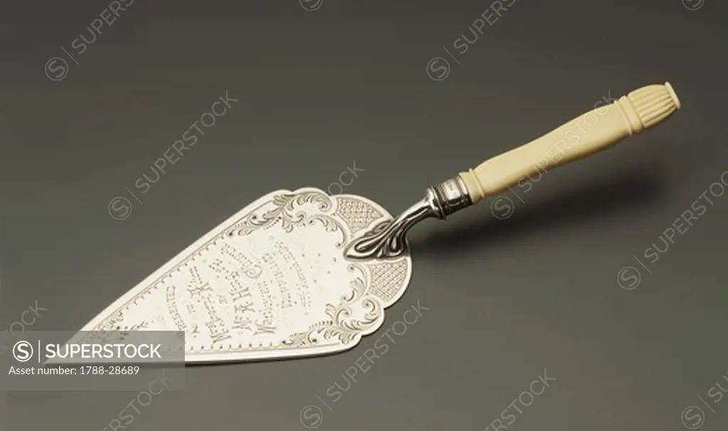Silversmith's Art, England 20th century. Commemorative silver trowel with ivory, carved handle and engraved with naturalistic motifs and a dedication. Manufacture John and William Deakin, 1904.