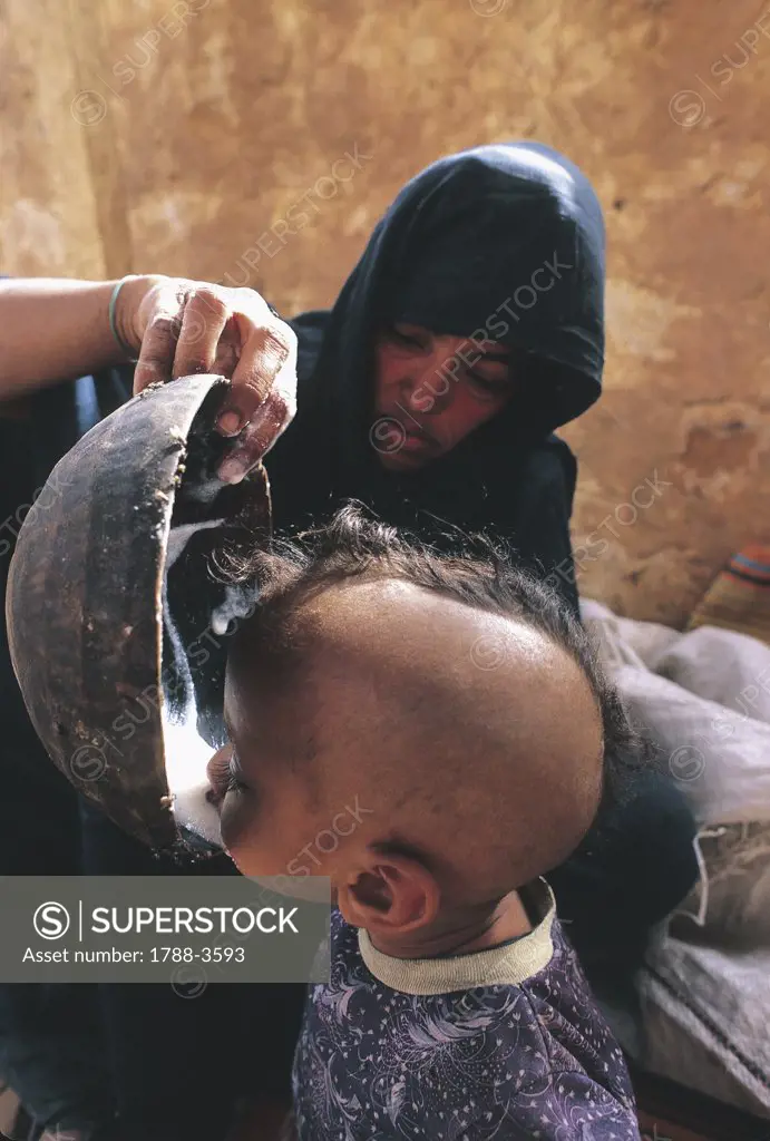 Mother feeding milk to her son