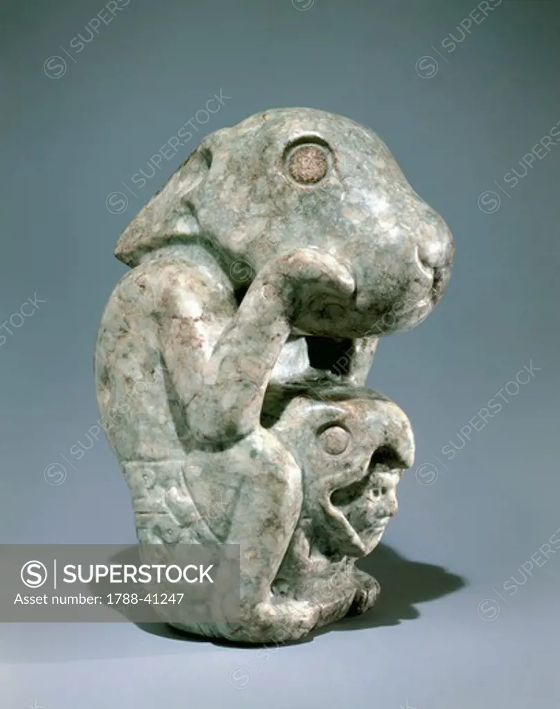 Jade rabbit statue with a warrior head with a helmet in the form of an eagle between its legs. Artefact from Mexico. Aztec Civilization, 15th Century.