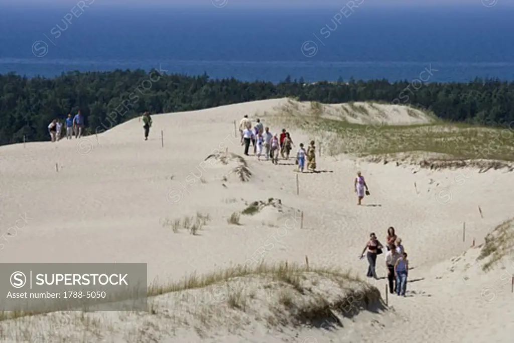 Lithuania, Klaipeda County, Curonian Spit, Vecekrugas, people walking on coastal sand dunes