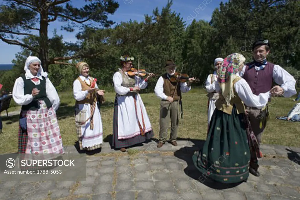 Lithuania, Klaipeda County, Curonian Spit, Nida, people wearing traditional costumes playing music and dancing