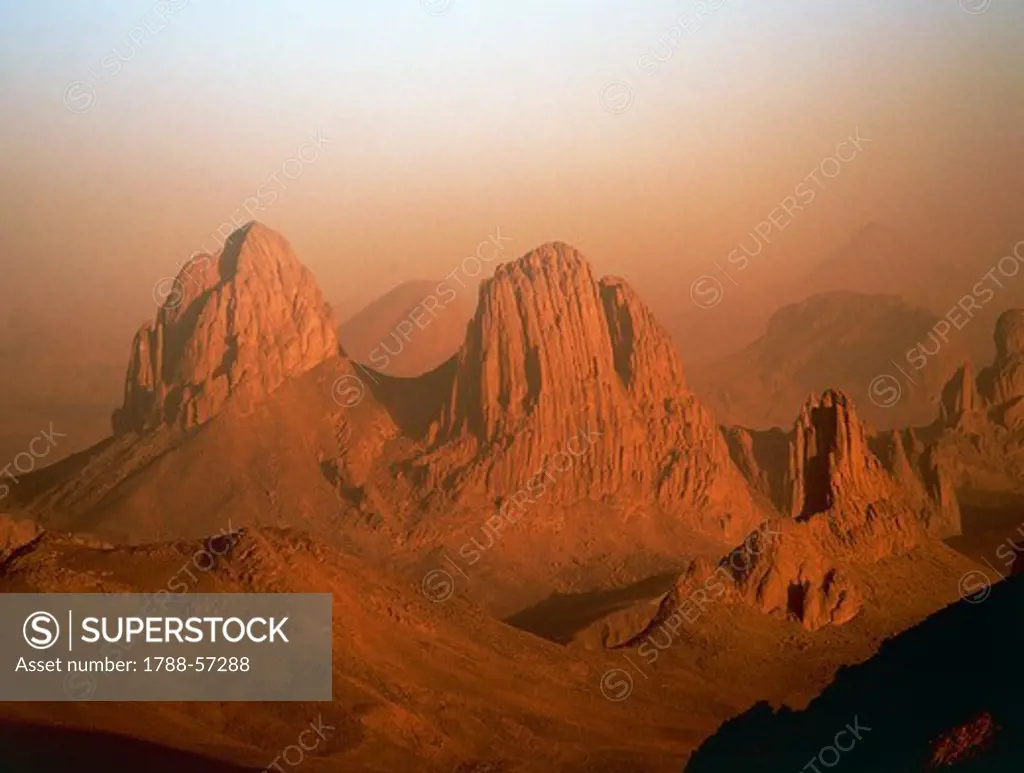 Hoggar Mountains (Ahaggar), mountain range formed from volcanic rocks, Sahara Desert, Algeria. Sunset.