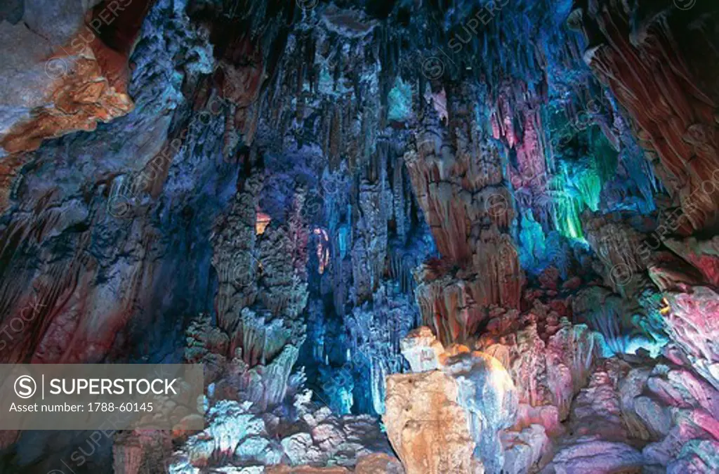 Stalactites and stalagmites artificially lit by neon lights, Reed Flute Cave (Ludi Yan), Monte Guangming, Guilin, China.