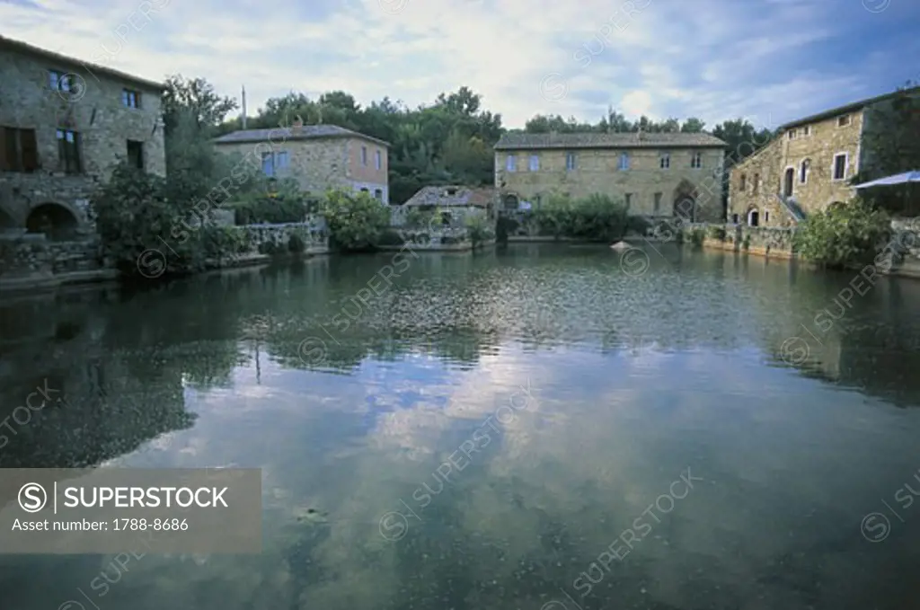Reflection of buildings in water, Roman Baths, Bagno Vignoni, Orcia Valley, Tuscany, Italy