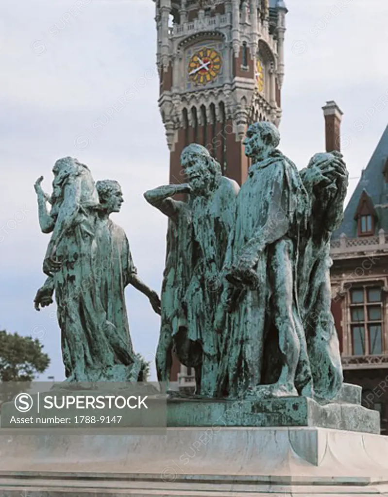 Statues on a monument in front of a clock tower, The Burghers of Calais, Calais, France