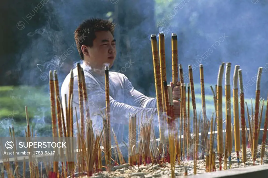 China - Guangdong - Guangzhou (or Canton). Bright Filial Piety Temple (Guangxiao-Si). Man burning incenses
