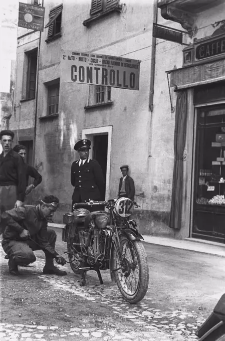 A driver inflating the tyre of his motorcycle at a checkpoint, Radio Auto Motorcycle Rally, June 29, 1936, Genoa, Italy, 20th century.