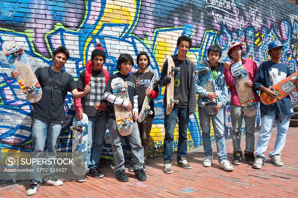 Colombia, Cundinamarca Department, Bogota, La Candelaria District, young people with their skateboard in front of a mural