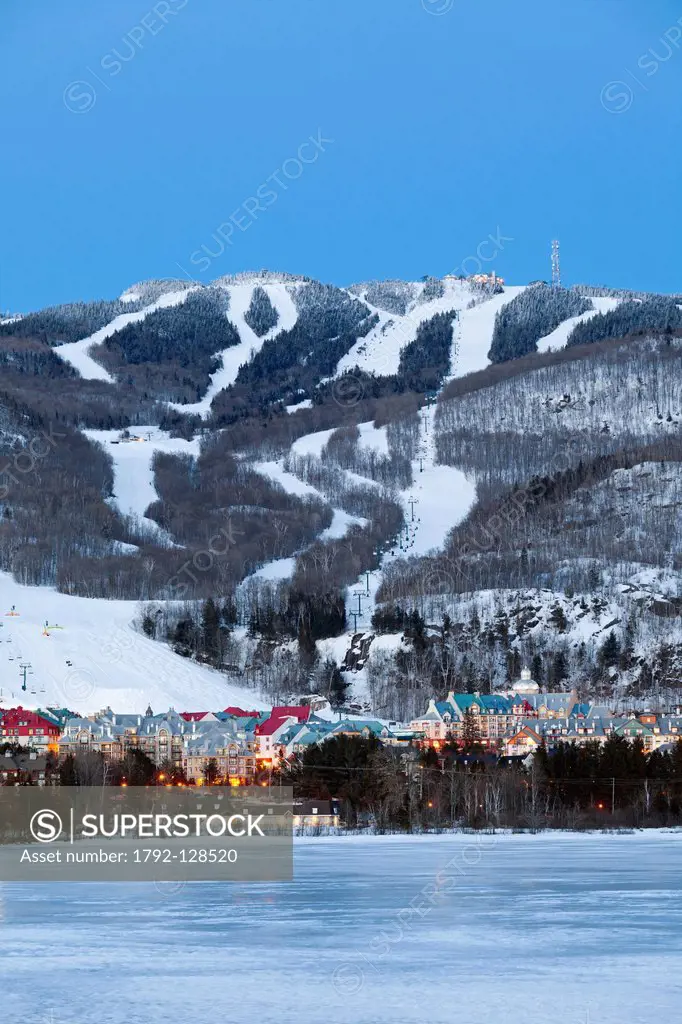 Canada, Quebec province, Laurentians region, Mont Tremblant, ski resort, the village and ski slopes at night seen from Tremblant lake frozen in winter