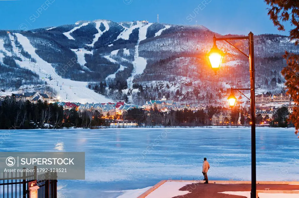 Canada, Quebec province, Laurentians region, Mont Tremblant, ski resort and ski slopes lit at night seen from the Tremblant lake pier