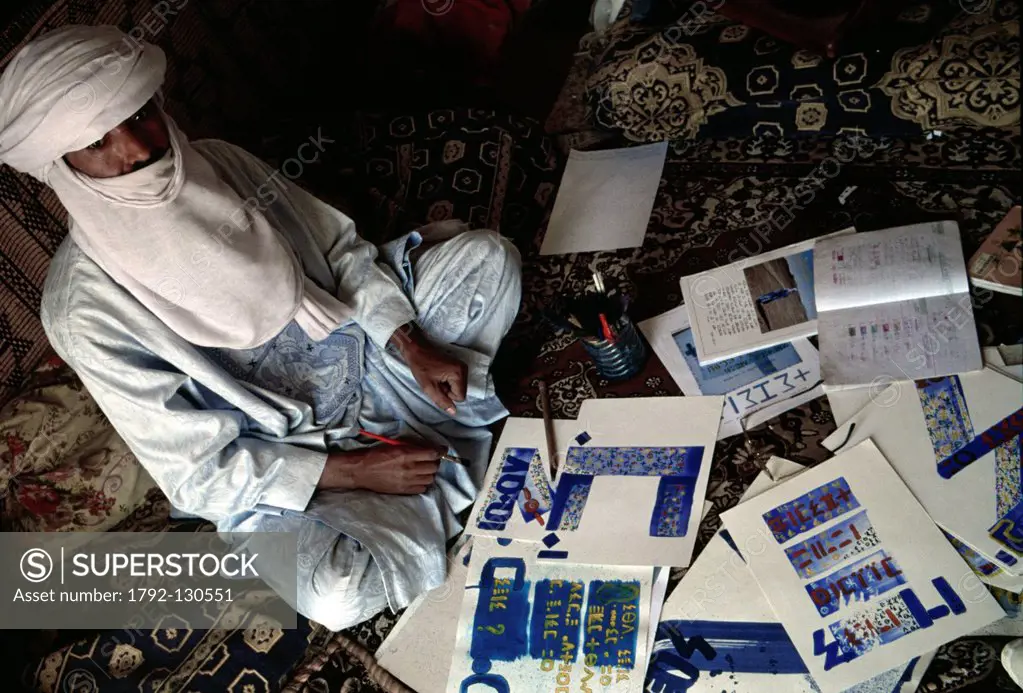 Algeria, Sahara, Hoggar Ahaggar Mountains, Tamanrasset, Tuareg man in his working room with its texts and calligraphies