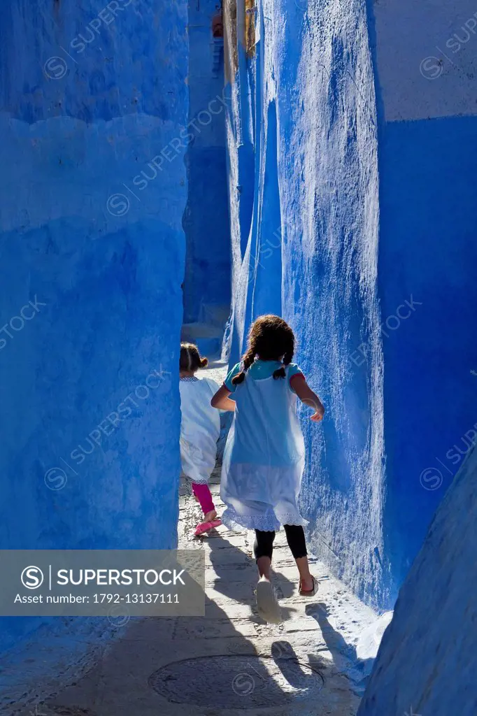 Morocco, Rif region, Chefchaouen, children playing in the streets of the medina blue