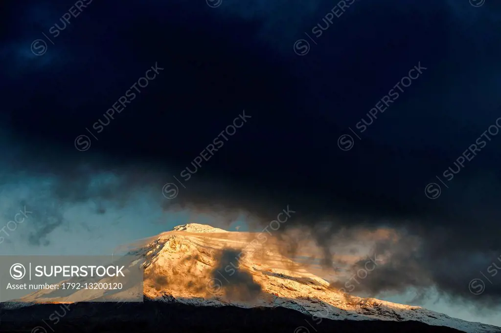 Ecuador, Chimborazo, Natural Reserve of Chimborazo, snow-capped Chimborazo volcano at sunrise under a stormy sky