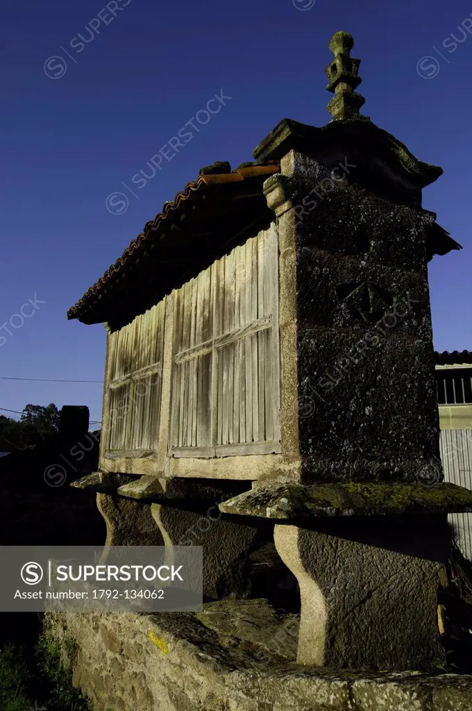 Spain, Galicia, Palas de Rei, traditional galician stone drier on stilts, in stone, with wooden walls and tile roof, called horreo