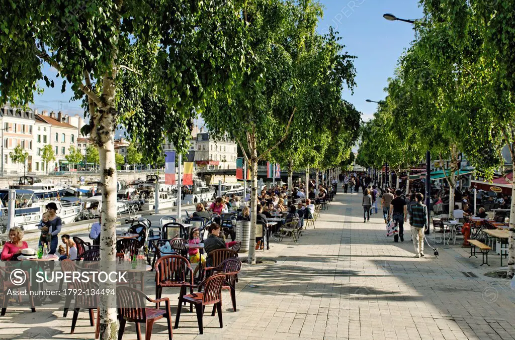 France, Meuse, Verdun, Quai de Londres, sidewalk cafe on a pedestrian walkway along the Meuse river, consumers sitting around the tables