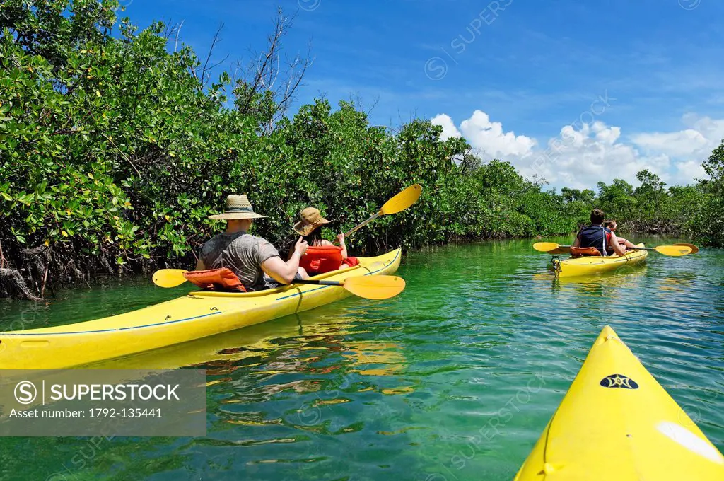 Bahamas, Grand Bahama Island, Old Freetown, Lucayan National Park, couple wearing hats aboard canoe kayak in a mangrove