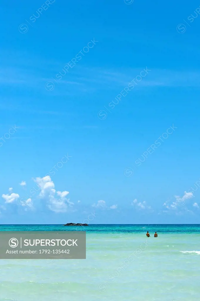 Bahamas, Grand Bahama Island, Old Freetown, couple walking in the water of a beach with transparent water