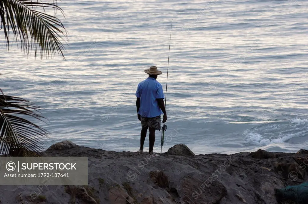 France, Martinique French West Indies, Grand Riviere, fisherman and his fishing rod along the Caribbean Sea