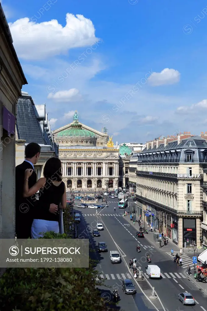 France, Paris, avenue de l´opera, lovers on the balcony of their suite at hotel Edouard 7 with opera Garnier built 1875 in the background