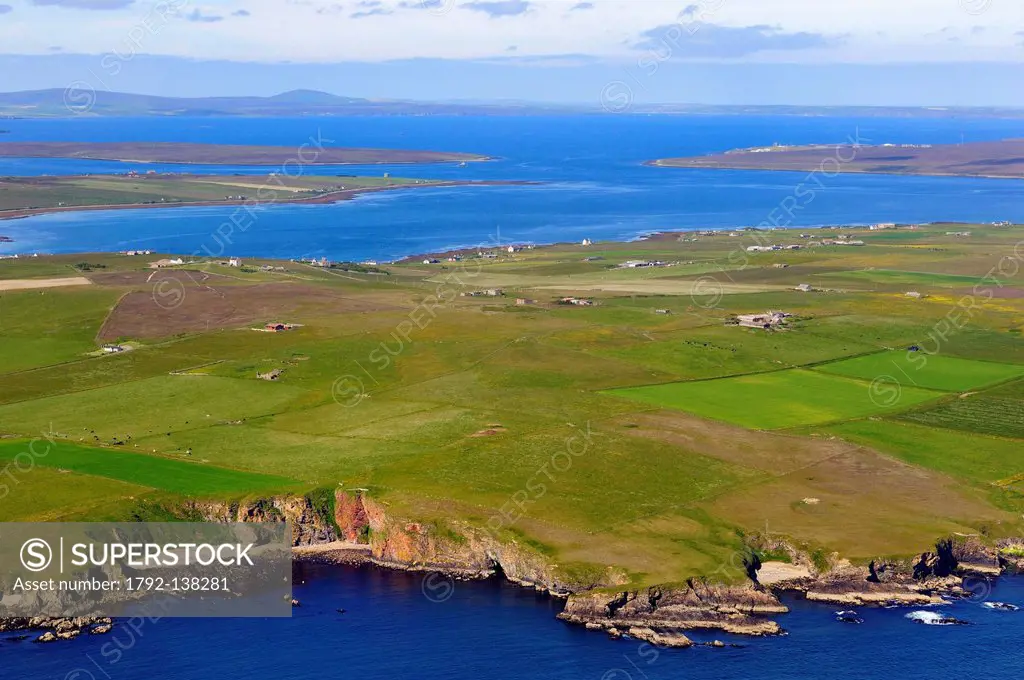 United Kingdom, Scotland, Orkney Islands, fields and scattered farms on the peninsula of South Walls Hoy in front of Scapa Flow aerial view