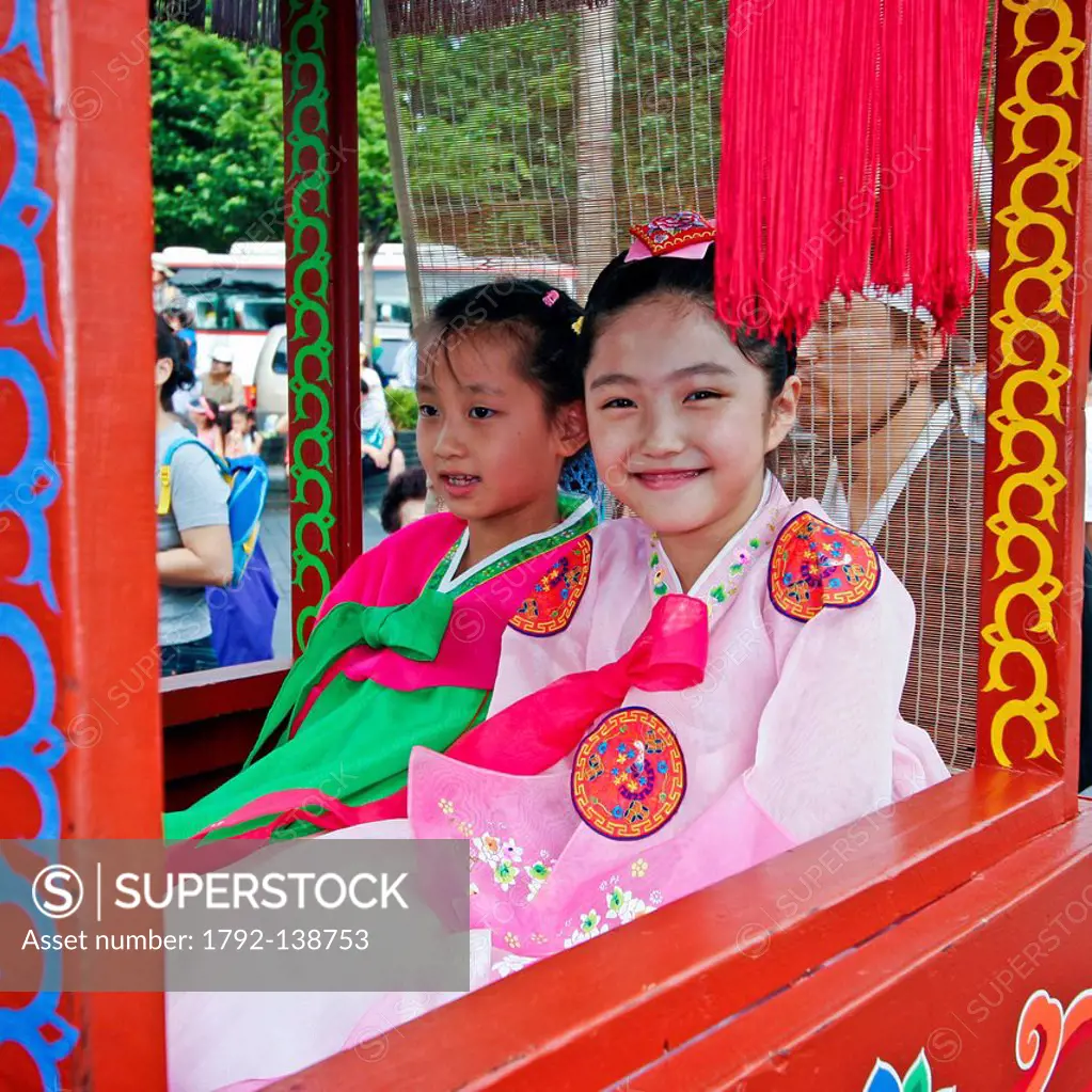 South Korea, Seoul, Insadong Disctrict, two young girls wearing Korean traditional dress hanbok and sitting in a palanquin