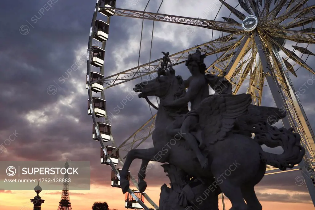 France, Paris, Jardin des Tuileries, Place de la Concorde, sculpture representing the Fame seated on Pegasus and the Grande Roue at sunset