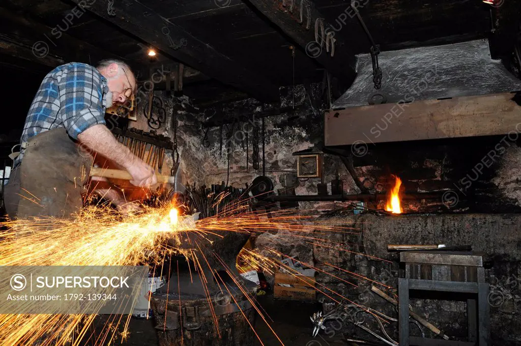 France, Territoire de Belfort, Etueffont, Museum of the Forge, a blacksmith at work, making a Damascus steel knife