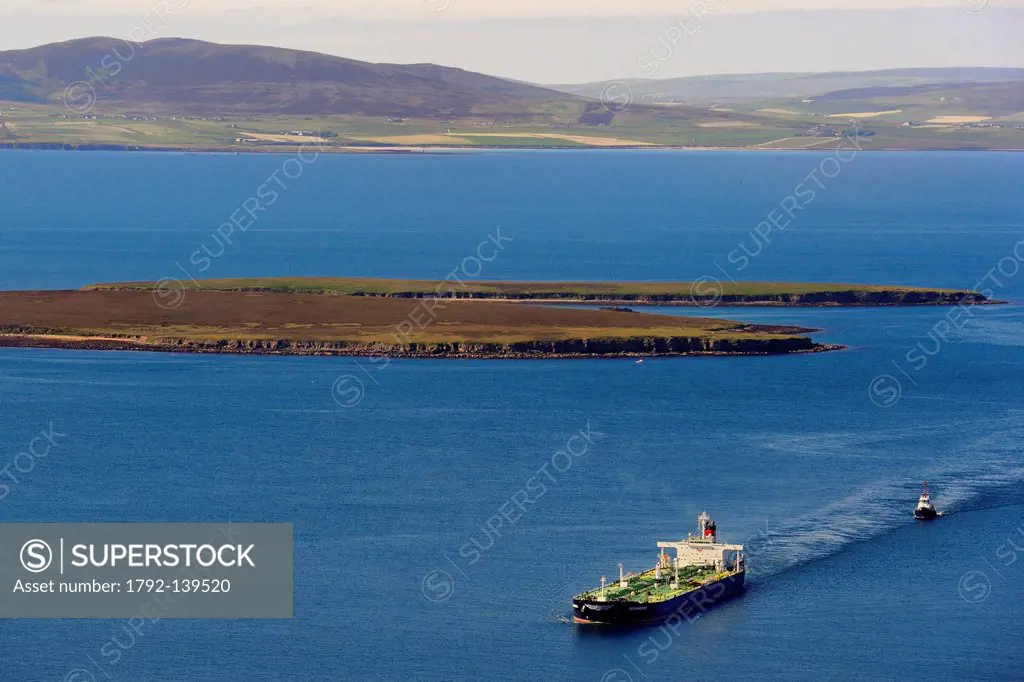 United Kingdom, Scotland, Orkney Islands, tanker navigating in Scapa Flow off the island of Flotta and the island of Mainland in the background aerial...