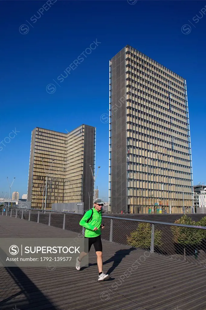 France, Paris, jogger on the pedestrian footbridge Simone de Beauvoir by the architect Dietmar Feichtinger and Bibliotheque Nationale de France BNF by...