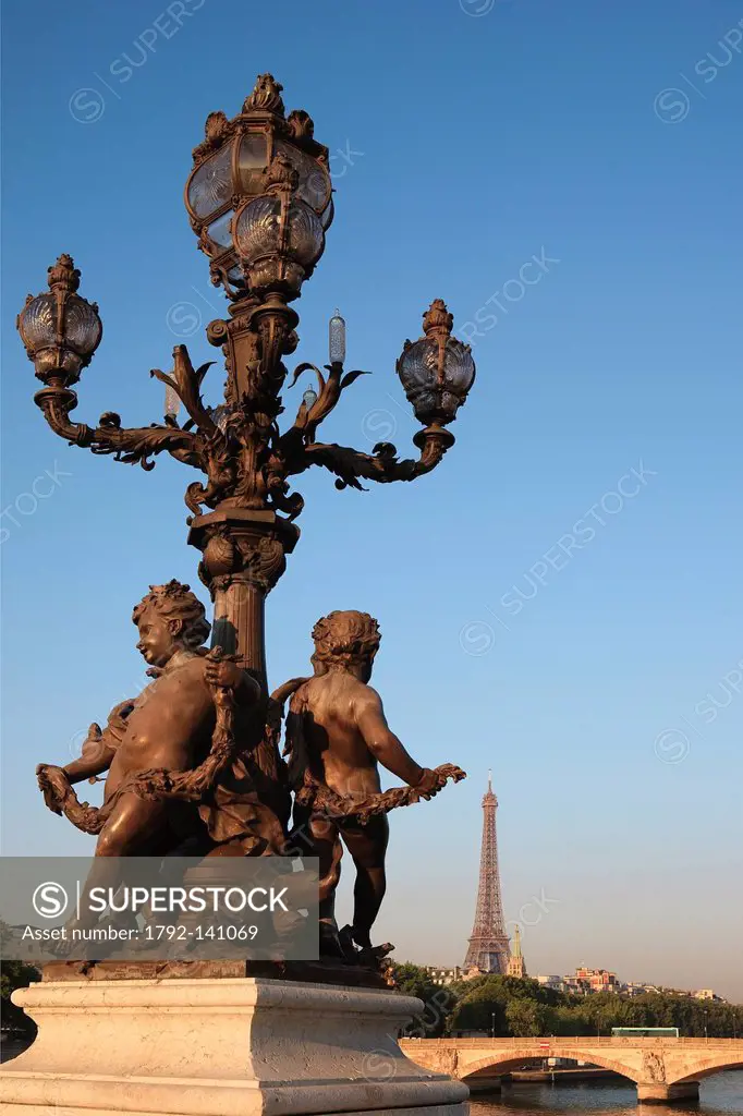 France, Paris, the putti supporting a candelabra by the sculptor Henri Gauquie on the Pont Alexandre III and Eiffel Tower in the background