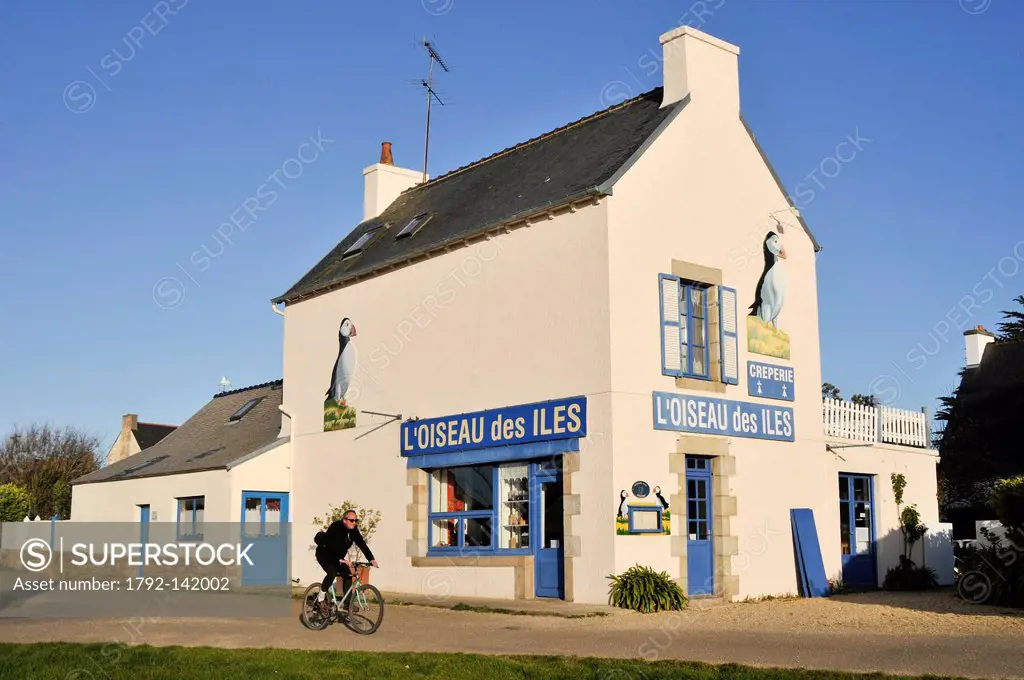France, Cotes d´Armor, Brehat island, man cycling past the pancake house the bird islands