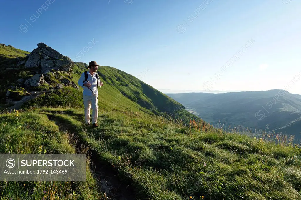 France, Cantal, Parc Naturel Regional des Volcans d´Auvergne Natural Regional Park of Auvergne Volcanoes, Pas de Peyrol, hiker on a hiking trail at th...